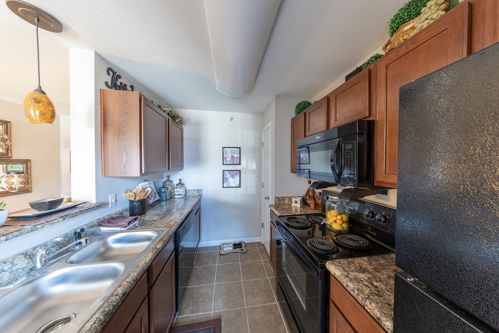 A kitchen with a black stove top oven and a black microwave.