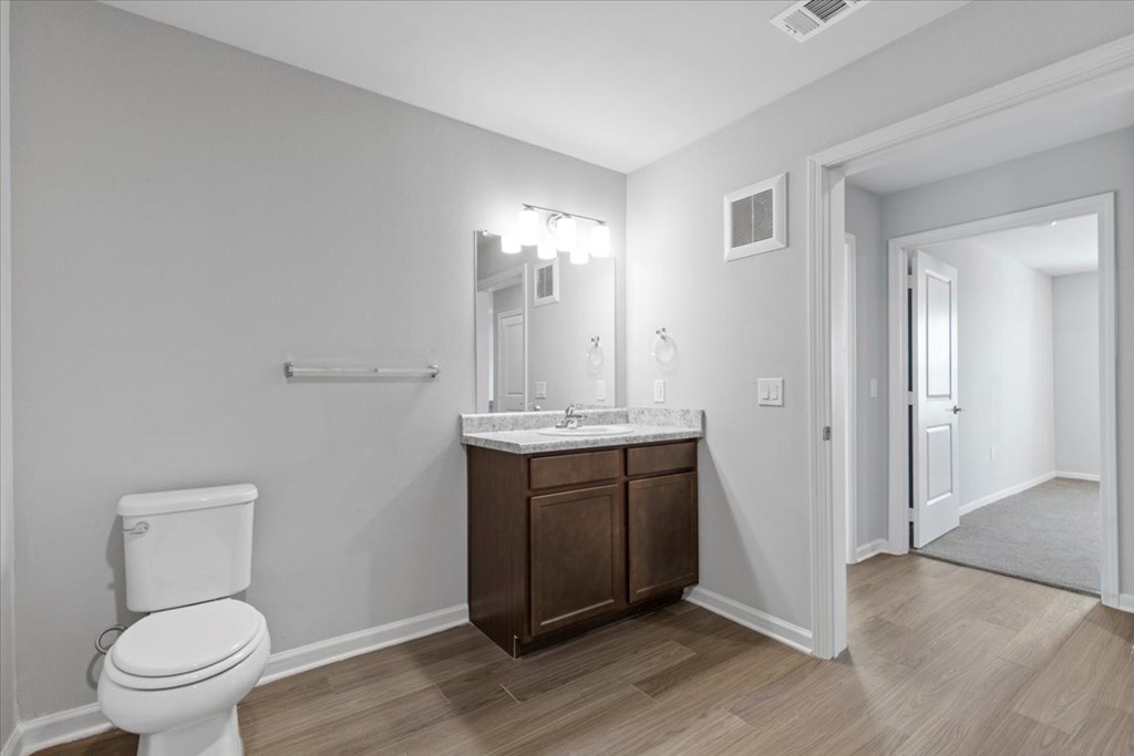 A white toilet sits next to a sink in a bathroom.