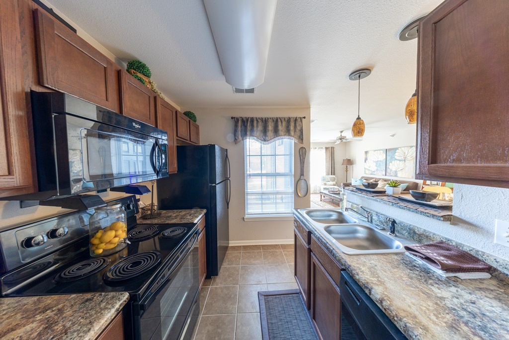 A kitchen with black appliances and wooden cabinets.