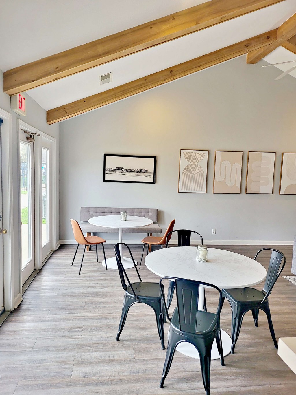 a dining room with tables and chairs and paintings on the wall