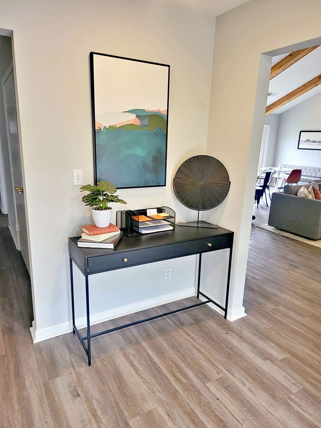 a living room with a table and a painting on the wall
