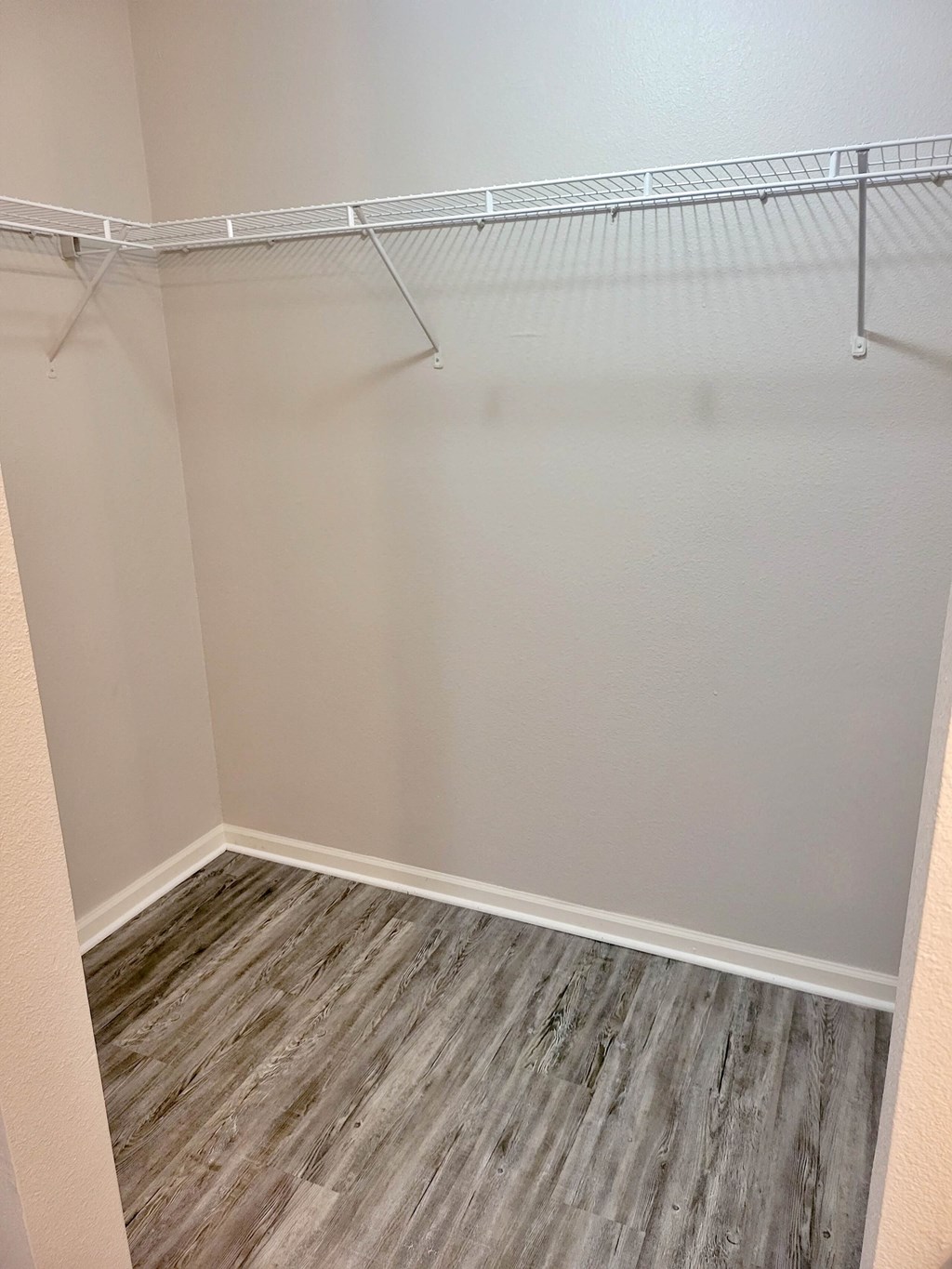 an empty closet in a home with wood flooring