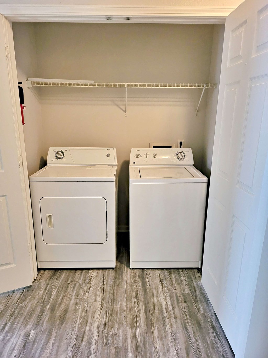 a washer and dryer in a room with wood floors and a closet