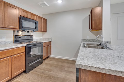 A kitchen with wooden cabinets and a black oven.