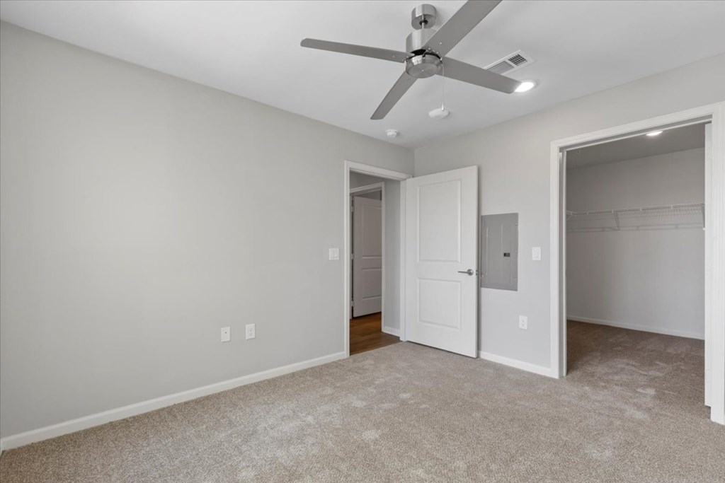 A room with a ceiling fan and two doors.