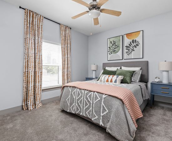 a bedroom with a bed and a ceiling fan at the Vue apartments in Indianapolis