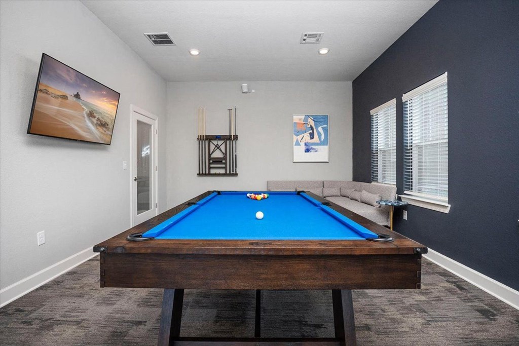 a games room with a pool table and a tv