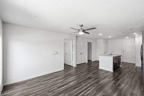 A spacious room with a ceiling fan and wooden flooring.