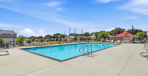 A large swimming pool with a diving board in the middle.
