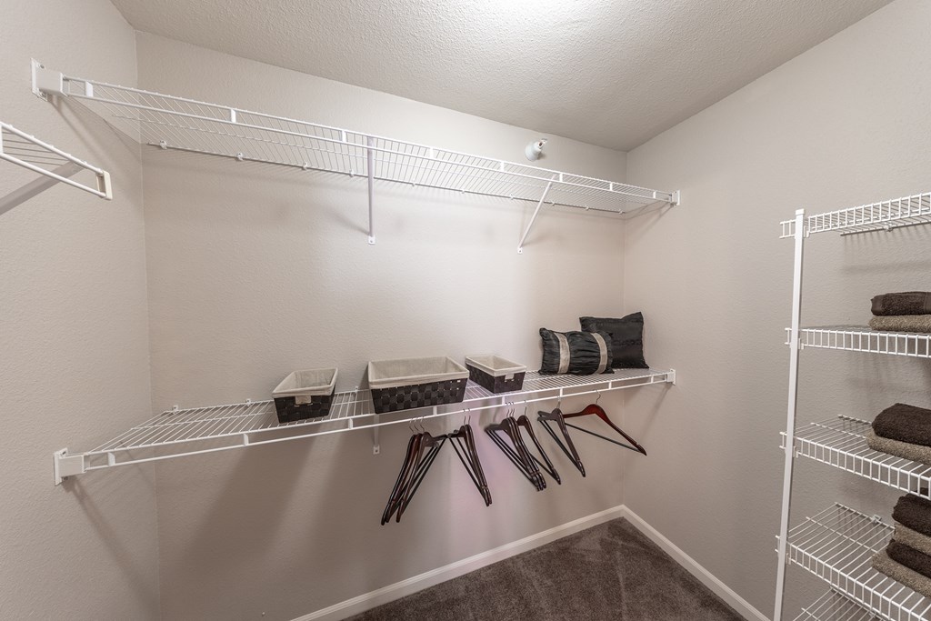 A white closet with shelves and storage baskets.