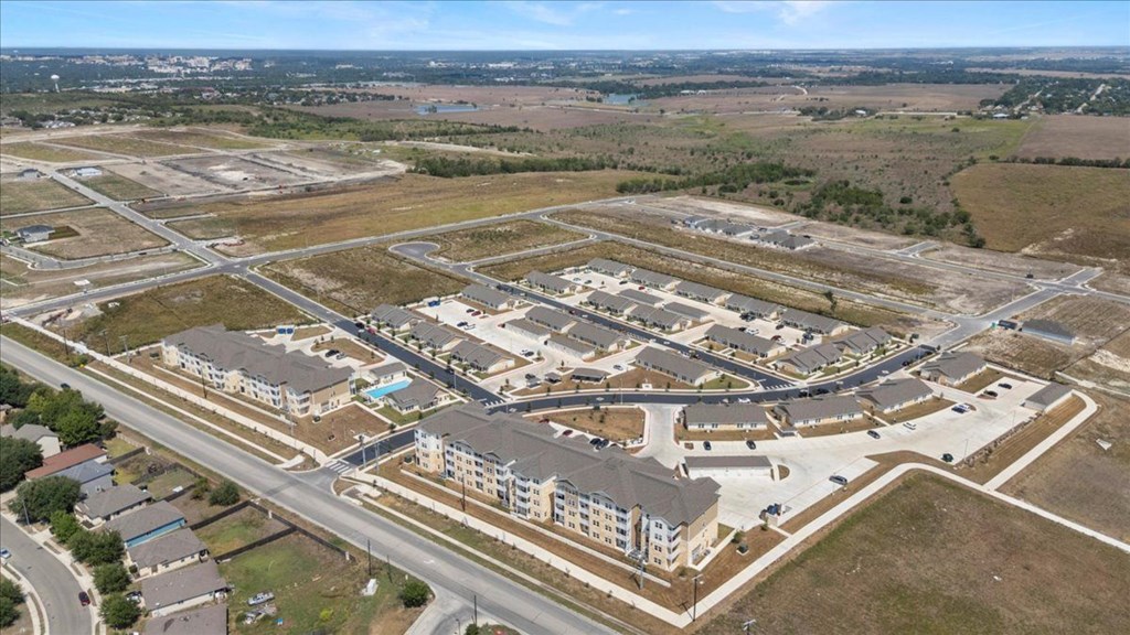 A large, modern building complex with a parking lot in front.
