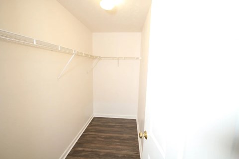 A room with a white wall and a wooden floor.