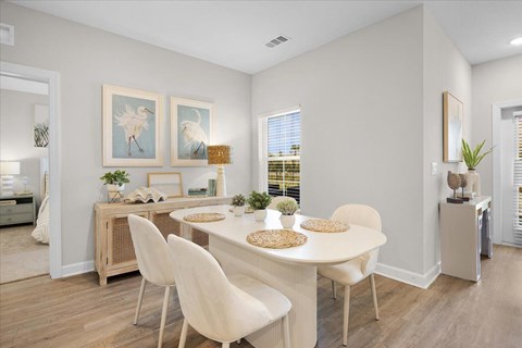 A dining room with a white table and chairs.