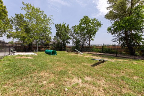A green tarp is in the middle of a grassy field.
