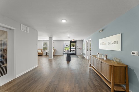 A hallway with a wooden floor and a white wall with a sign that says "Oakmont".