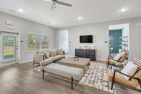 A living room with a couch, chair, and television.