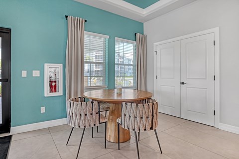 A dining room with a table and chairs.