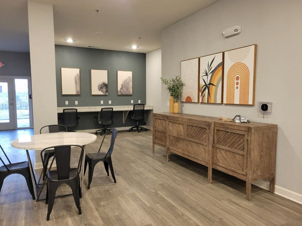 a communal area with a table and chairs and a long end table at Agave East Apartments