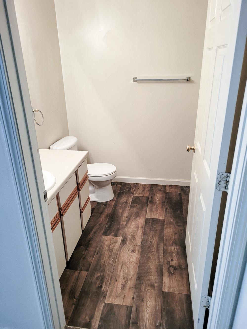 Bathroom with a toilet sink and mirror at Canterbury House apartments in Monticello, Indiana