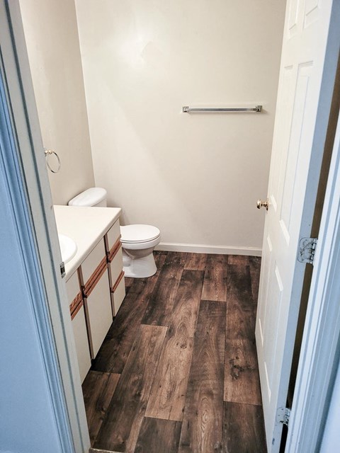 Bathroom with a toilet sink and mirror at Canterbury House apartments in Monticello, Indiana