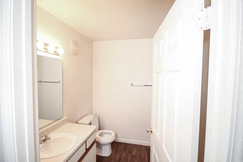 Bathroom with a toilet sink and mirror at Canterbury House apartments in Warsaw, IN