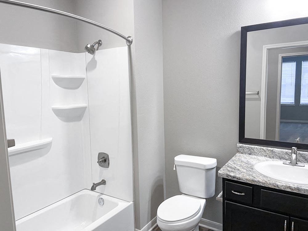 Bathroom with shower, toilet, and sink at Promenade Luxury apartments in Beaumont, Texas