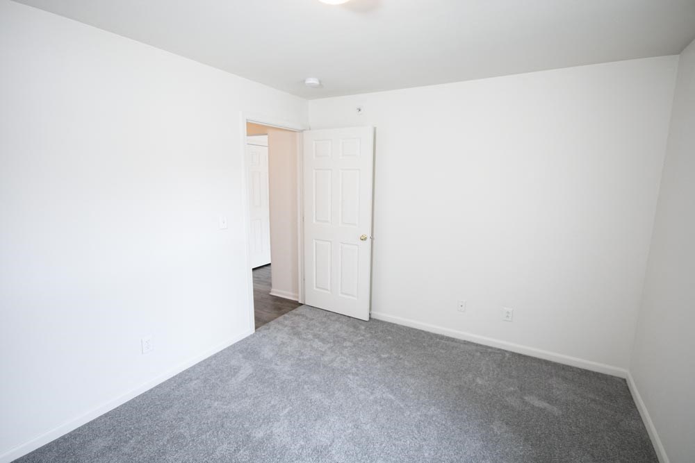 Bedroom with white walls and carpet at Canterbury House Newburgh Apartments in Newburgh, IN