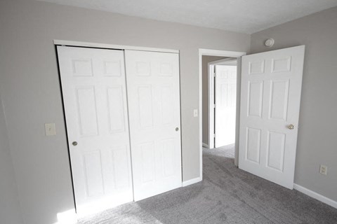 Bedroom with two closets and a doorway at Conner Court apartments in Connersville, IN
