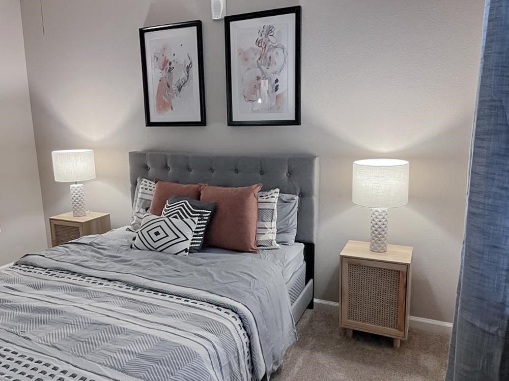A bed with night stand and lamp at The Lofts at Canterbury in Slidell, Louisiana