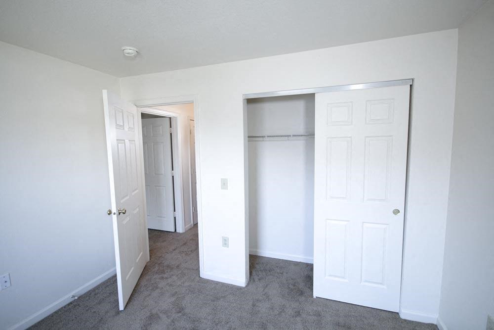 Empty bedroom with a closet and a door open at Canterbury House apartments in Warsaw, IN