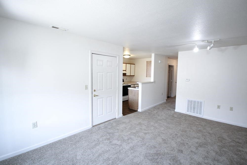 Empty living room with a kitchen in the background at Canterbury House apartments in Warsaw, IN