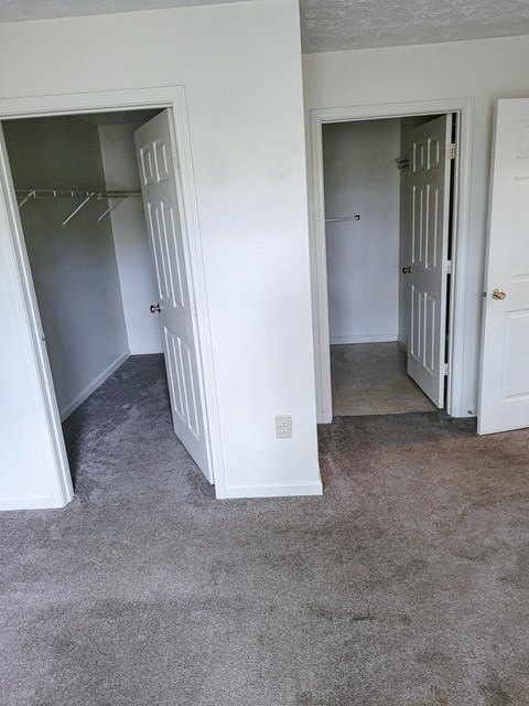 A walk in closet in a bedroom with a tiled floor at Canterbury House apartments in Monticello, Indiana