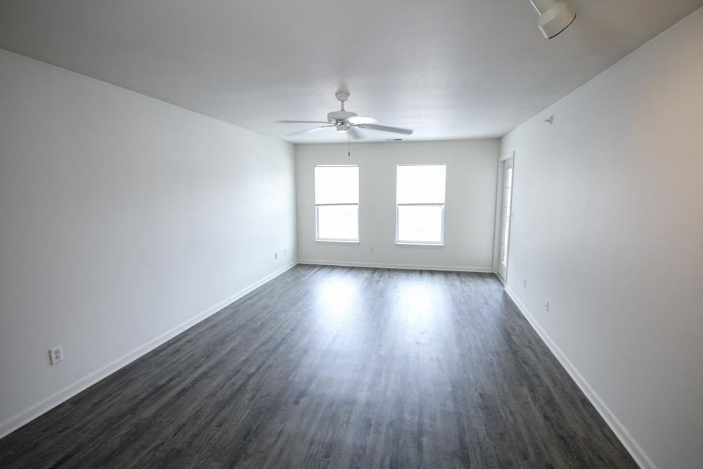 Empty living room with white walls and a ceiling fan at Canterbury House Newburgh Apartments in Newburgh, IN