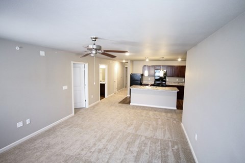 A living room with a television and a ceiling fan.