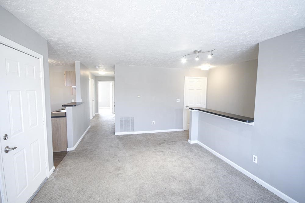 An empty living room with carpet at Cobalt Apartments in Kokomo, Indiana
