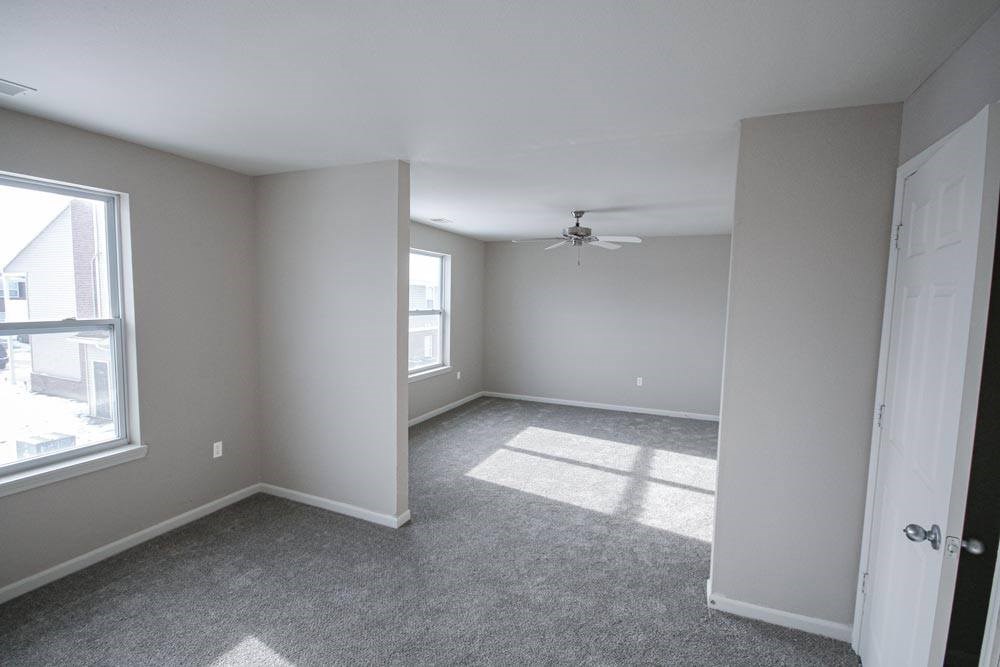 A room with a ceiling fan and a carpeted floor.