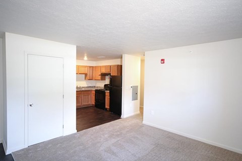 A kitchen area with a refrigerator, sink, and cabinets.
