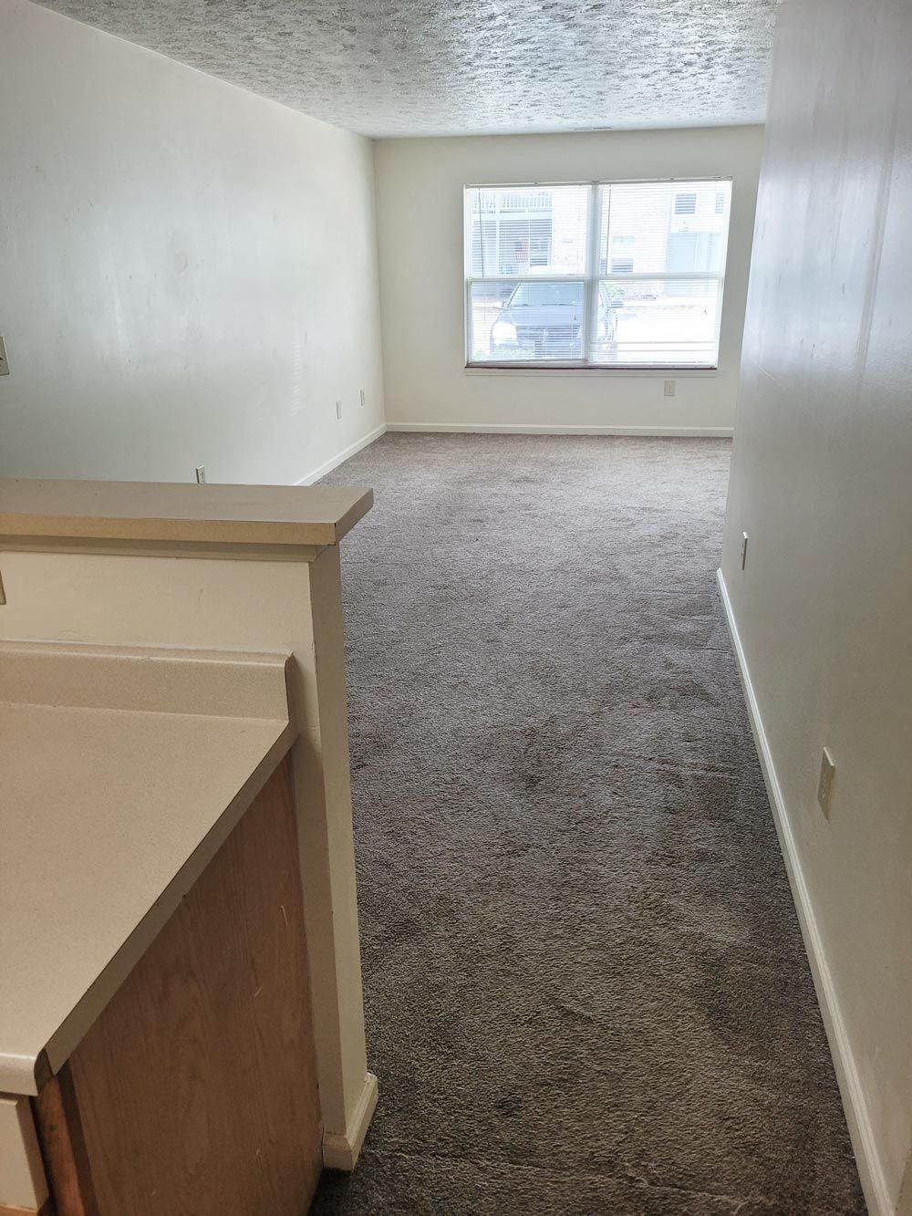 Empty room with a large window at Canterbury House apartments in Monticello, Indiana