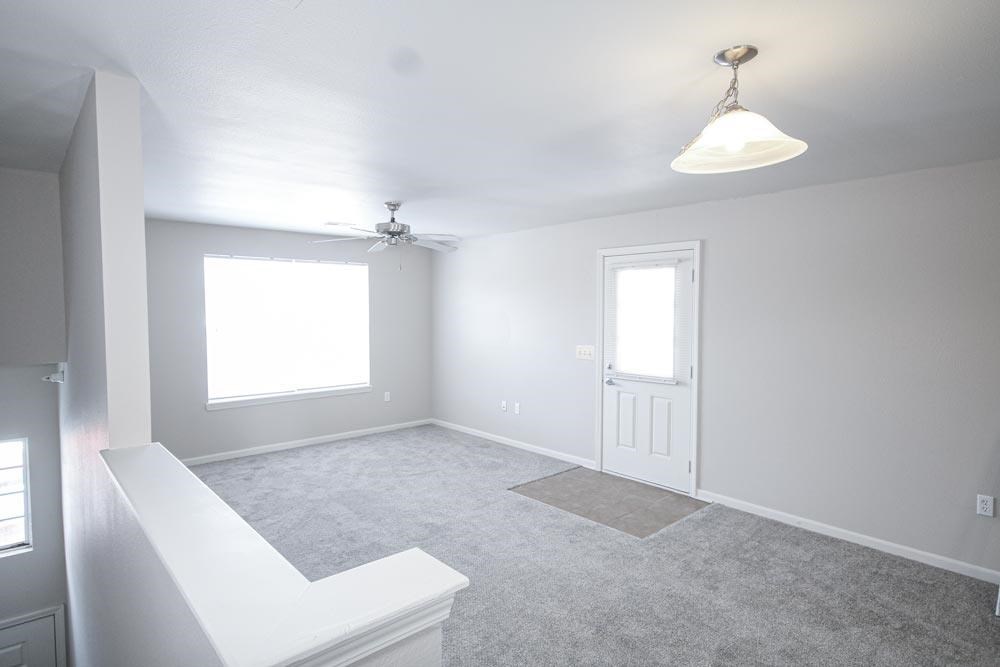 A white room with a ceiling fan and a window.