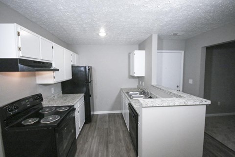 Kitchen with white cabinets and black appliances at Canterbury House apartments in Tipton, Indiana