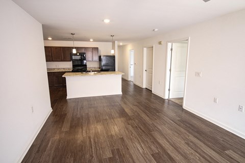 A kitchen with a white island and wooden floors.
