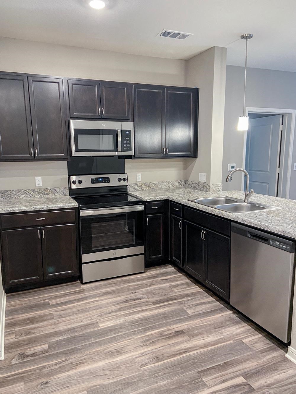 Kitchen with stove and sink at Promenade Luxury apartments in Beaumont, Texas