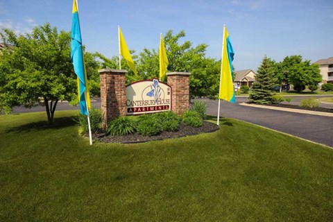 a sign in the grass for Canterbury Apartments in Kalamazoo, MI
