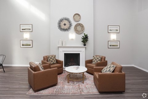 A living room with a fireplace and brown couches.