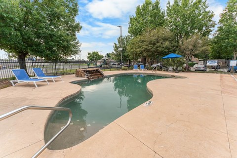 A small pool with a slide and a fence.