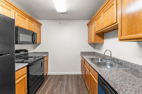 A kitchen with wooden cabinets and black appliances.