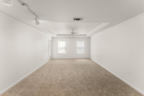 A spacious room with carpeted floor and white walls.