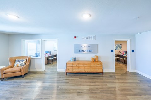 A room with a couch, a bed, and a sign that says "SANDPIPER".