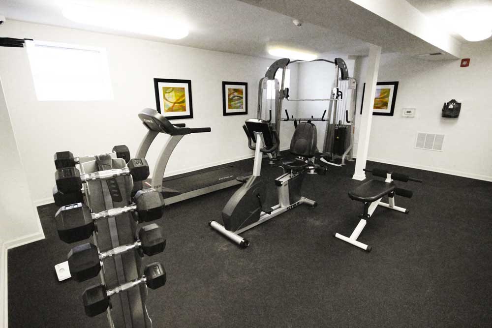 Fitness center with a treadmill, weight machines and dumbbells at The Enclave at Meridian
