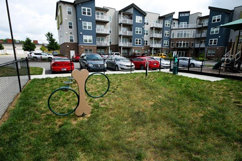 A playground with a swing set in front of apartment buildings.